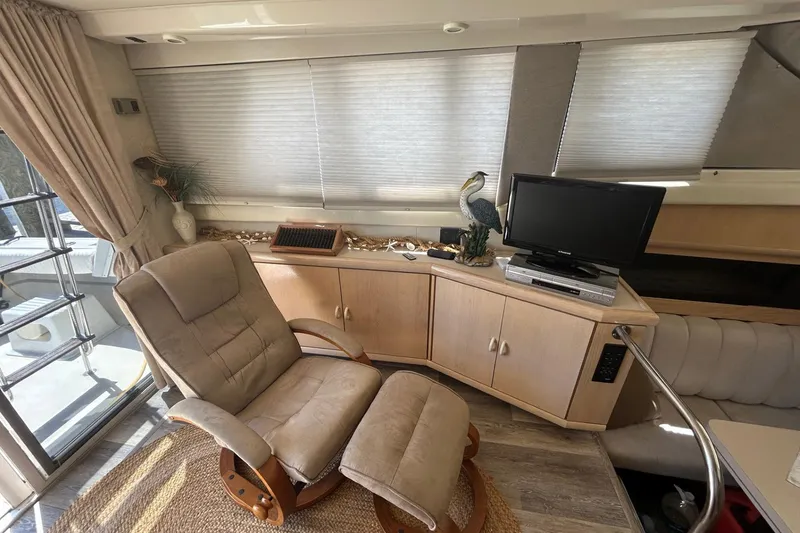 Slide: The Image of Interior of a 1990 Silverton 34 Convertible yacht with cozy seating and entertainment setup. - 21