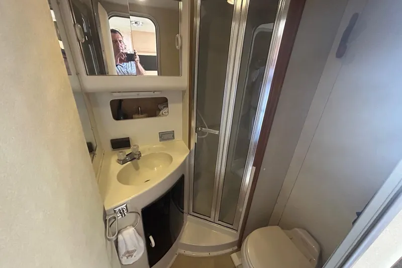 Slide: The Image of 1990 Silverton 34 Convertible yacht bathroom with shower, sink, and toilet. - 27