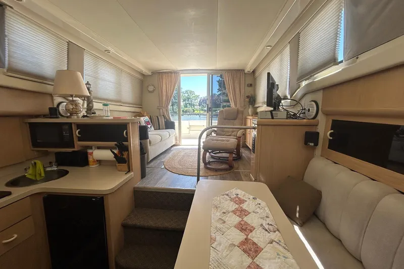 Slide: The Image of Interior of a 1990 Silverton 34 Convertible yacht, featuring cozy seating and modern amenities. - 28