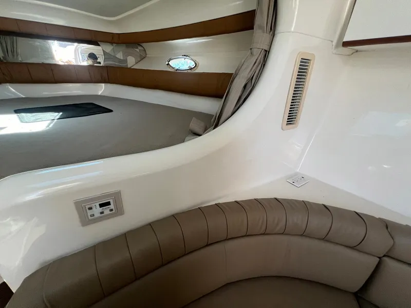 Slide: The Image of 1996 Silverton 310 Express cabin interior with seating and porthole. - 15