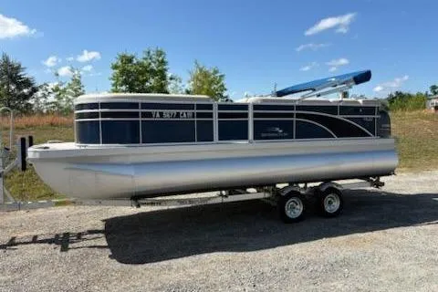 The Image of 2017 Bennington 22SLX pontoon boat on trailer under clear blue sky. - 1