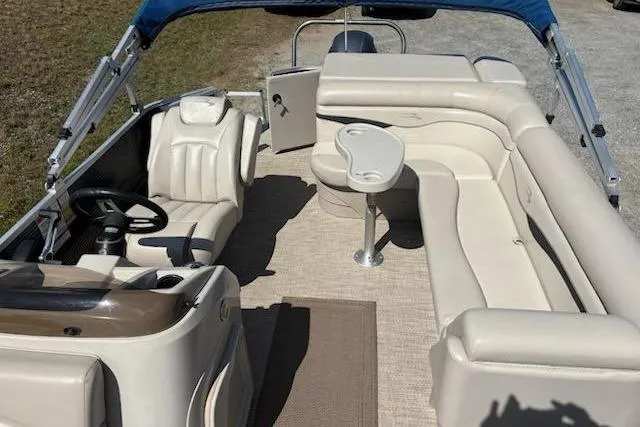 Slide: The Image of 2017 Bennington 22SLX pontoon boat interior with beige seating and a small table. - 14