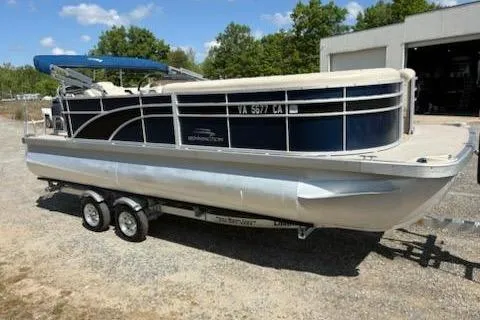 Slide: The Image of 2017 Bennington 22SLX pontoon boat on trailer, parked outdoors under a clear blue sky. - 3