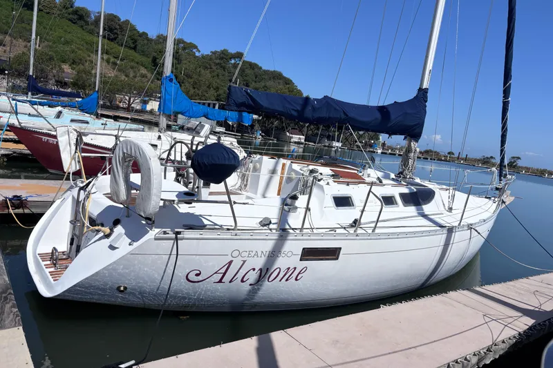 The Image of 1990 Beneteau Oceanis 350 sailboat docked, featuring sleek design and blue sails. - 1
