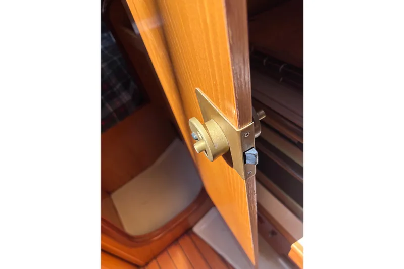 Slide: The Image of Wooden cabin door with brass latch on a 1990 Beneteau Oceanis 350 sailboat. - 11