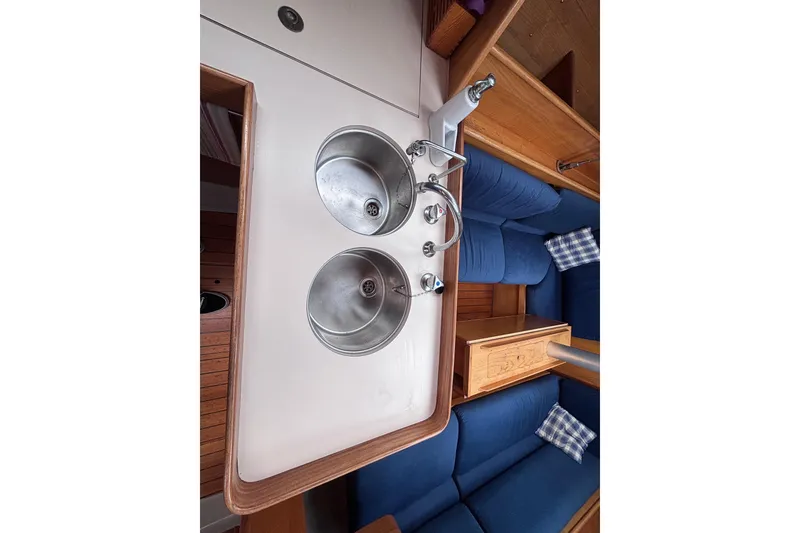 Slide: The Image of Interior of 1990 Beneteau Oceanis 350 yacht with dual sinks and blue seating. - 16