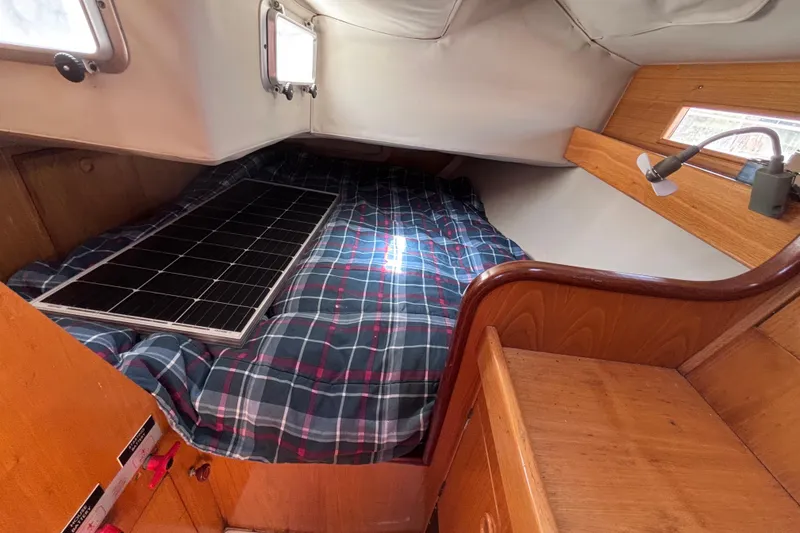 Slide: The Image of Cozy cabin interior of 1990 Beneteau Oceanis 350 with plaid bedding and solar panel. - 18