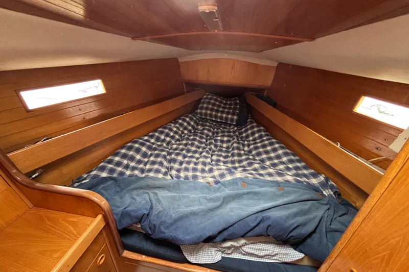 Slide: The Image of Cozy cabin interior of 1990 Beneteau Oceanis 350 sailboat with wooden finish and plaid bedding. - 19
