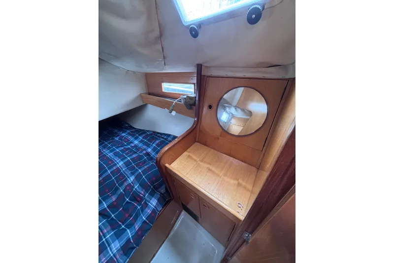 Slide: The Image of Cozy cabin interior of 1990 Beneteau Oceanis 350 sailboat with wooden furnishings and plaid bedding. - 25