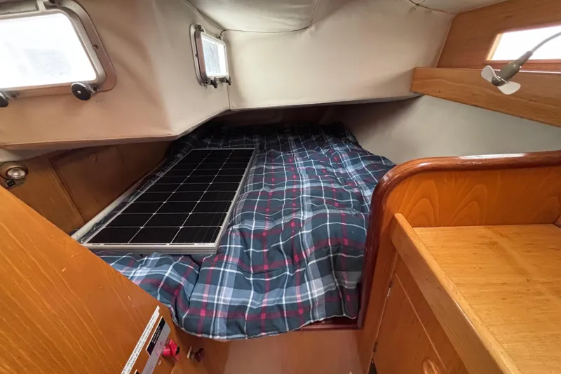 Slide: The Image of Cozy cabin interior of 1990 Beneteau Oceanis 350 sailboat with plaid bedding. - 26