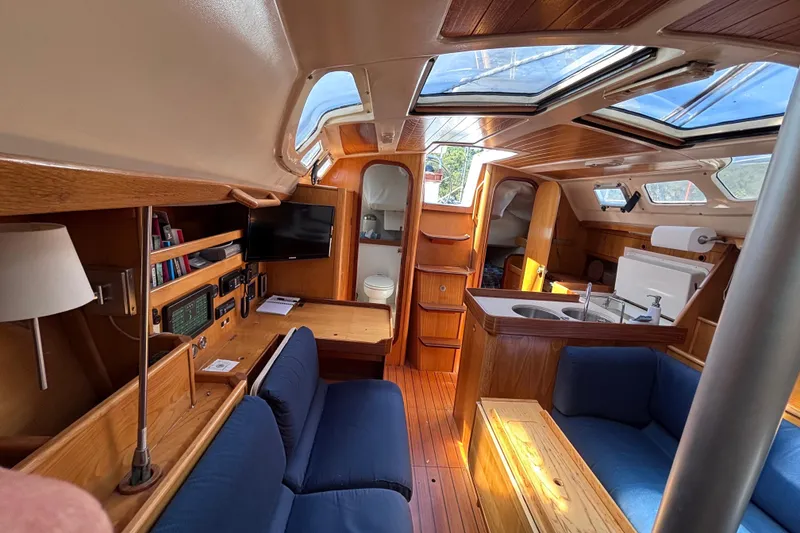 Slide: The Image of Interior of 1990 Beneteau Oceanis 350 sailboat with wood finish and blue seating. - 6