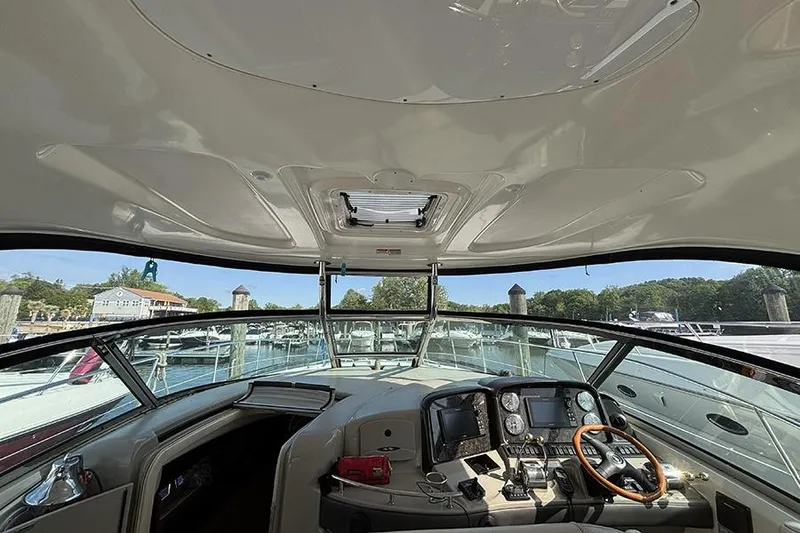 Slide: The Image of 2006 Sea Ray 44 Sundancer helm with navigation instruments and marina view. - 11