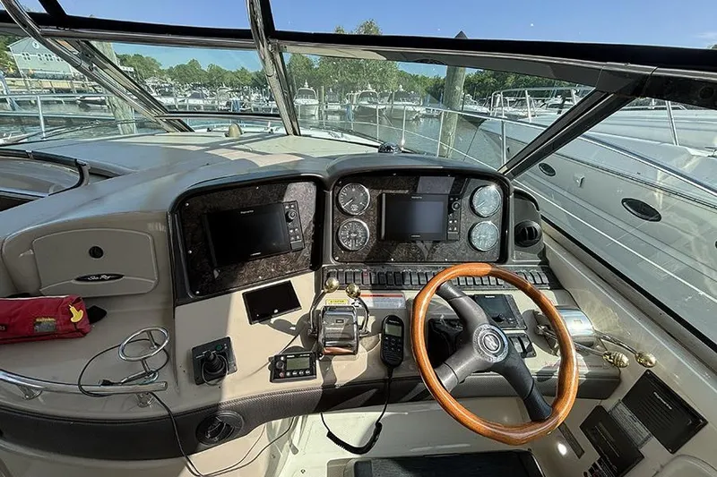 Slide: The Image of 2006 Sea Ray 44 Sundancer helm with wooden steering wheel and navigation instruments. - 12
