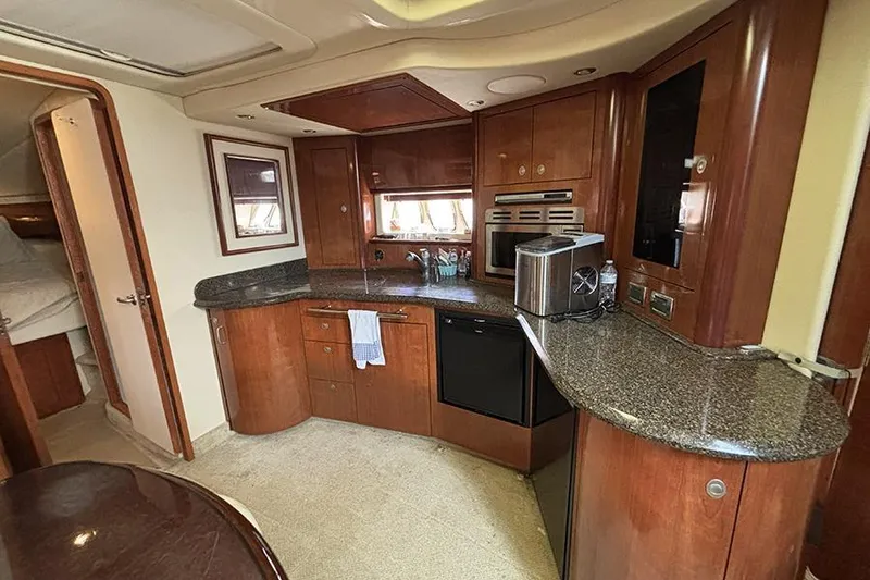 Slide: The Image of Luxurious 2006 Sea Ray 44 Sundancer yacht kitchen with wood cabinetry and modern appliances. - 13