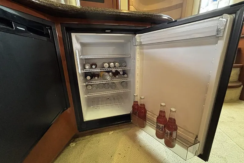 Slide: The Image of Open mini fridge stocked with beverages on a 2006 Sea Ray 44 Sundancer yacht. - 16