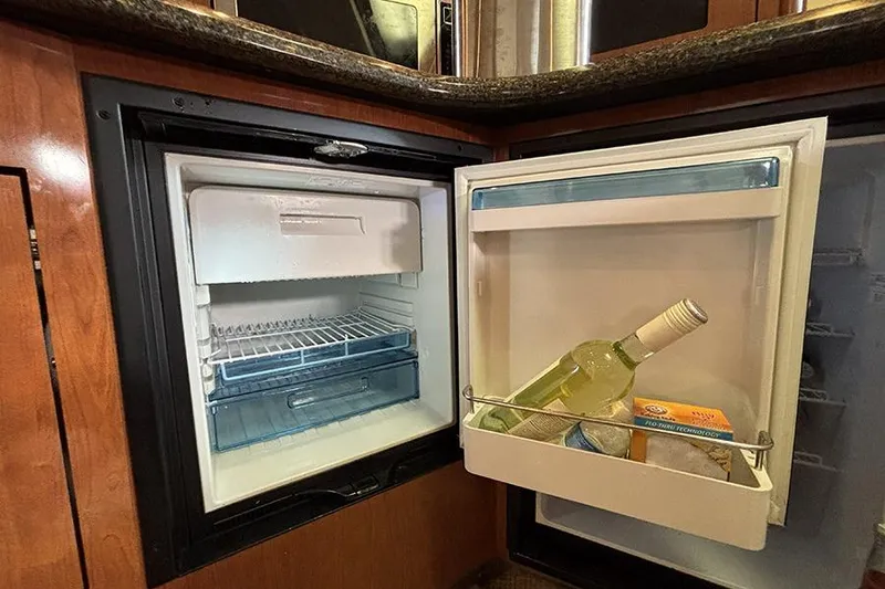 Slide: The Image of Mini fridge inside 2006 Sea Ray 44 Sundancer yacht, stocked with wine and essentials. - 17