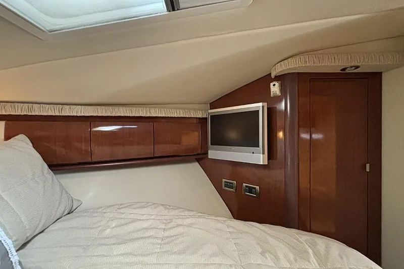 Slide: The Image of Luxurious cabin interior of 2006 Sea Ray 44 Sundancer yacht with TV and wood paneling. - 24
