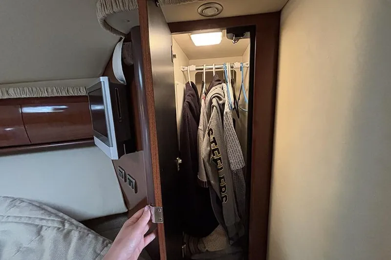 Slide: The Image of Closet interior on 2006 Sea Ray 44 Sundancer yacht with hanging clothes. - 25