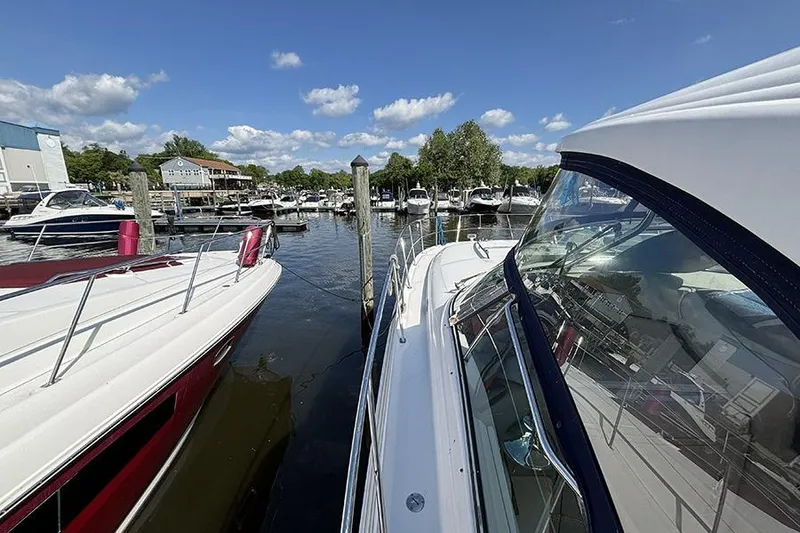 Slide: The Image of 2006 Sea Ray 44 Sundancer docked at a marina under a clear blue sky. - 28