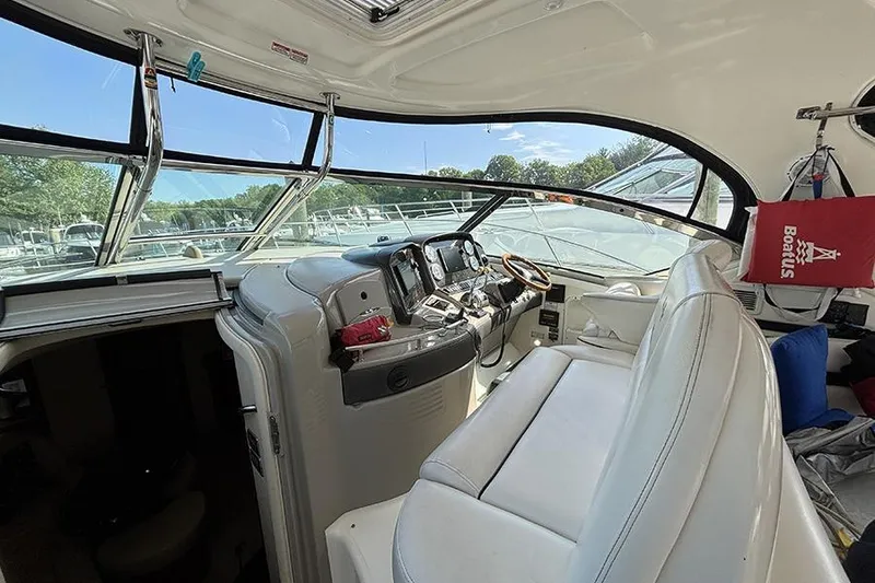 Slide: The Image of Interior view of 2006 Sea Ray 44 Sundancer yacht cockpit with white seating and control panel. - 9
