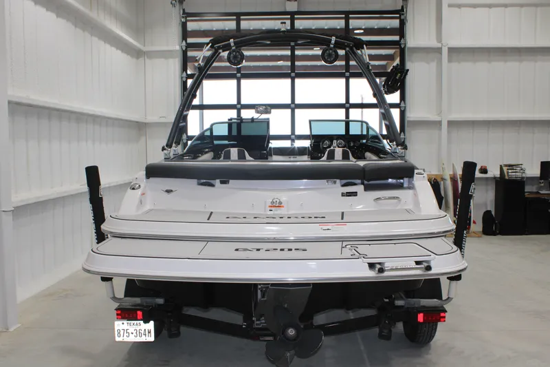 Slide: The Image of 2017 Glastron GT 205 boat in a garage, rear view showcasing swim platform and wakeboard tower. - 13