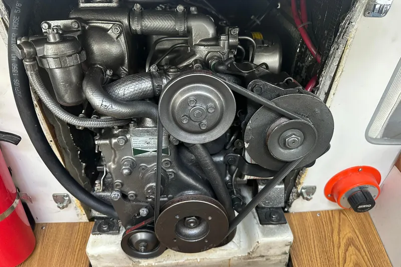 Slide: The Image of Engine compartment of a 1998 J Boats J/105 sailboat, featuring mechanical components and belts. - 21