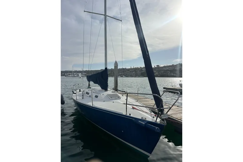 Slide: The Image of 1998 J Boats J/105 sailboat docked in a marina under a cloudy sky. - 5