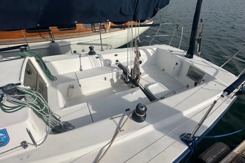 Slide: The Image of 1998 J Boats J/105 sailboat cockpit with rigging and winches, docked on calm water. - 7