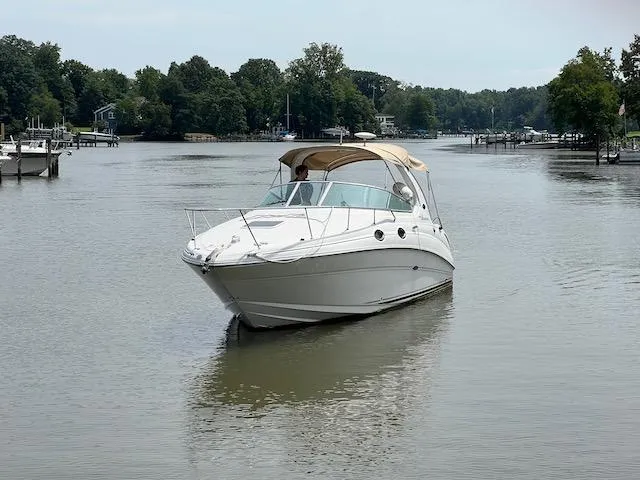 The Image of 2005 Sea Ray 280 Sundancer cruising on a calm river with lush green trees. - 0