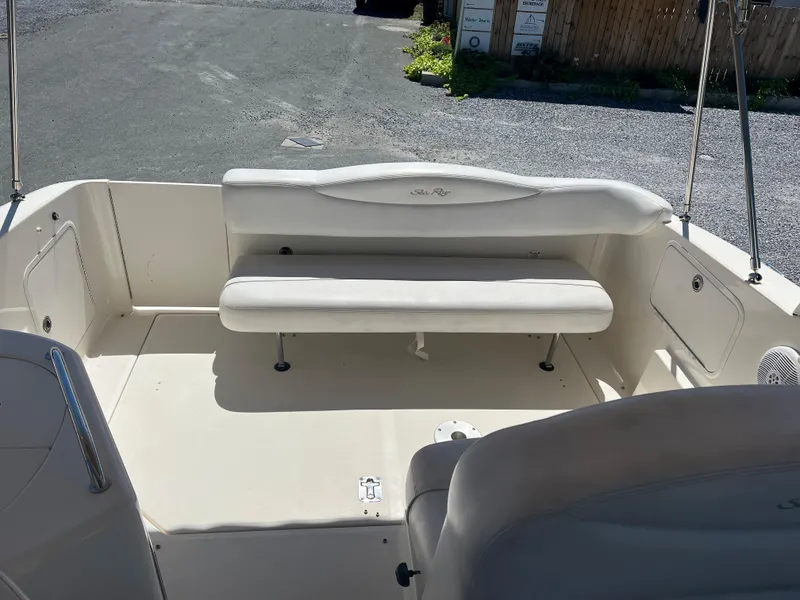 Slide: The Image of 2005 Sea Ray 280 Sundancer boat interior with white seating and spacious deck area. - 12