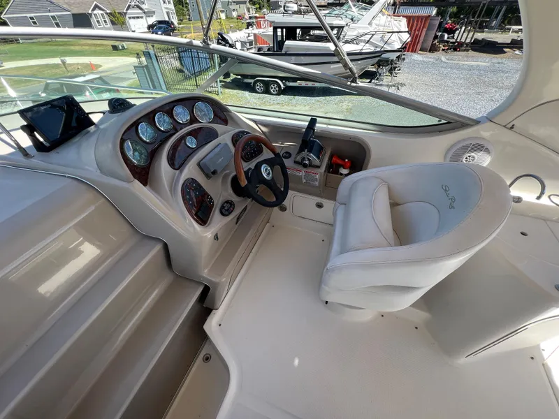 Slide: The Image of 2005 Sea Ray 280 Sundancer helm with steering wheel and control panel. - 18