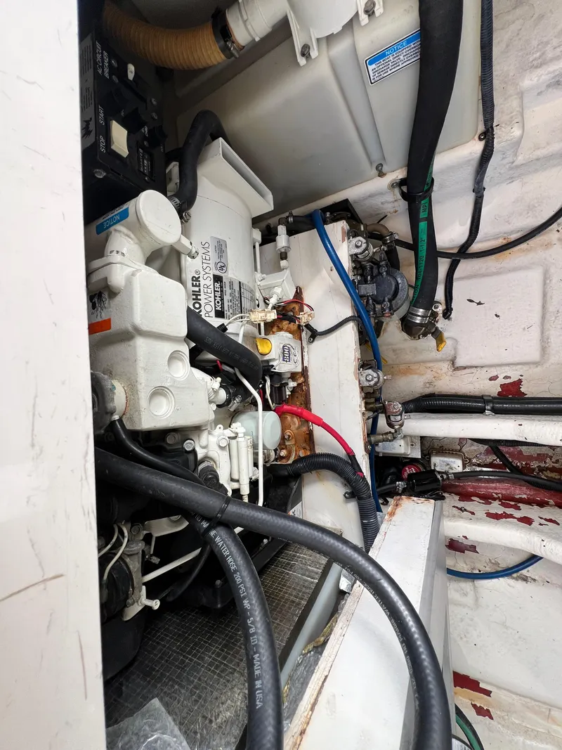 Slide: The Image of Engine compartment of a 2005 Sea Ray 280 Sundancer boat, showing mechanical components and wiring. - 34