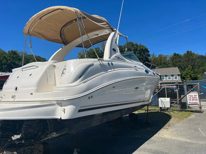 Slide: The Image of 2005 Sea Ray 280 Sundancer boat on display, featuring a beige canopy and sleek design. - 7