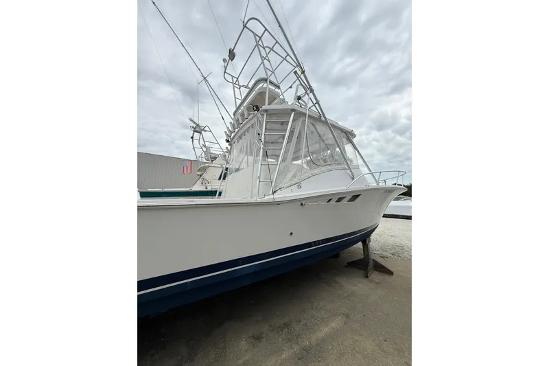 Slide: The Image of 1999 Luhrs Tournament 320 Open boat with tower, docked under cloudy skies. - 11