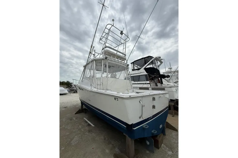 Slide: The Image of 1999 Luhrs Tournament 320 Open boat on dry dock under cloudy sky. - 3