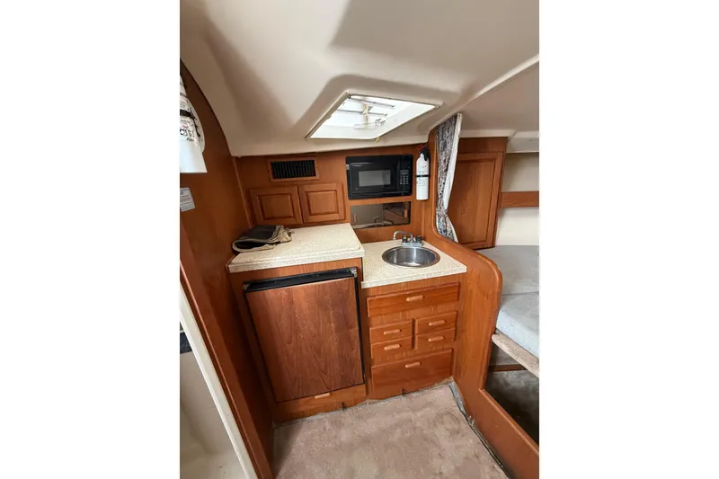Slide: The Image of 1999 Luhrs Tournament 320 Open cabin interior with kitchenette, sink, and storage. - 33