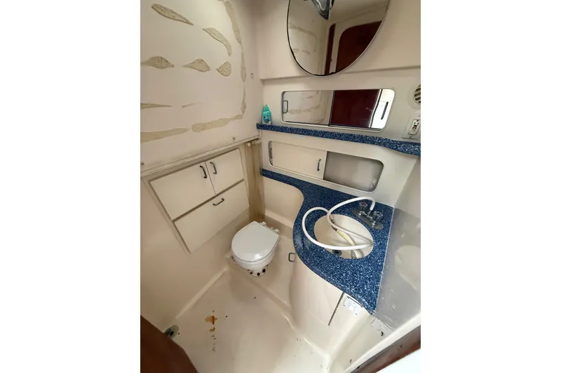 Slide: The Image of 1999 Luhrs Tournament 320 Open boat bathroom with blue countertop and white fixtures. - 37