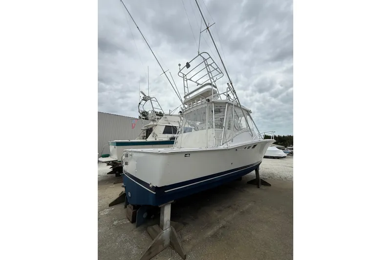 Slide: The Image of 1999 Luhrs Tournament 320 Open boat on stands, cloudy sky background. - 4