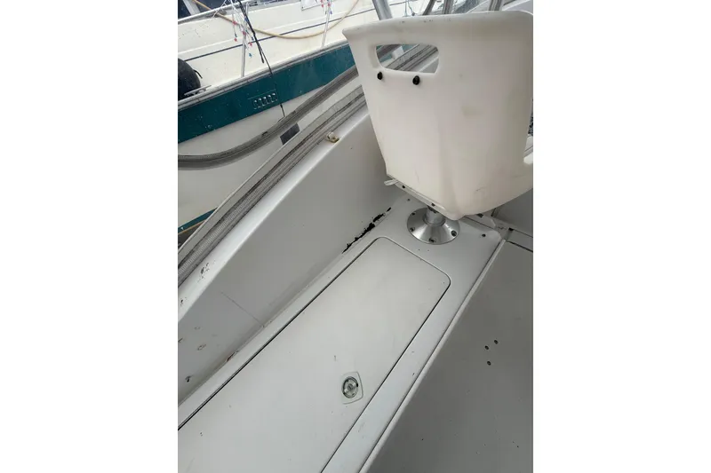 Slide: The Image of 1999 Luhrs Tournament 320 Open boat interior with white seating and storage compartment. - 43
