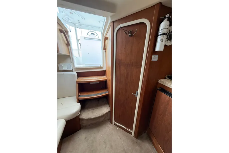 Slide: The Image of 1999 Luhrs Tournament 320 Open cabin interior with wooden door and seating area. - 45