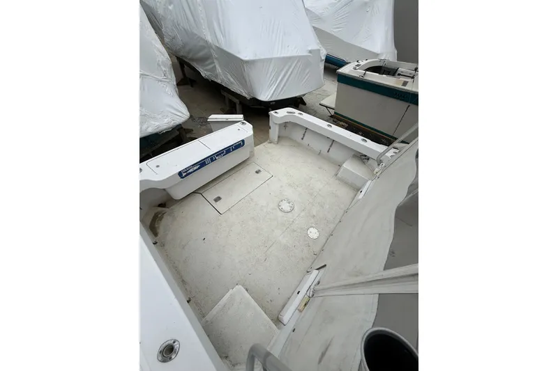 Slide: The Image of 1999 Luhrs Tournament 320 Open boat deck, white and spacious, with covered boats nearby. - 58
