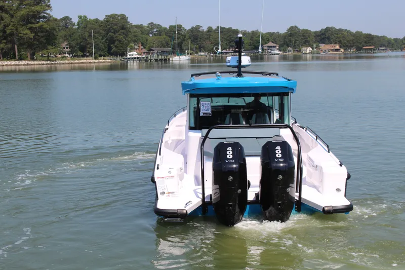 Slide: The Image of Axopar 37 XC Cross Cabin 2026 on calm water with twin outboard engines. - 4