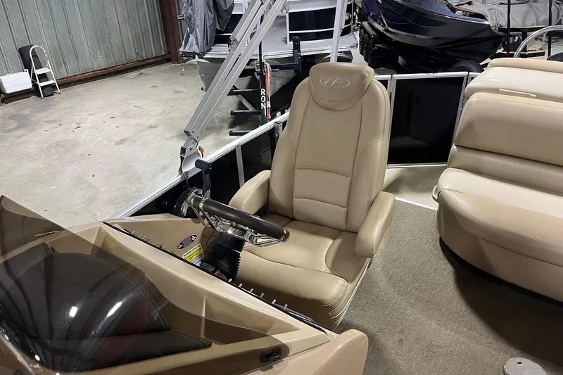 Slide: The Image of 2015 Harris Grand Mariner 250 boat interior with beige captain's chair and steering wheel. - 7