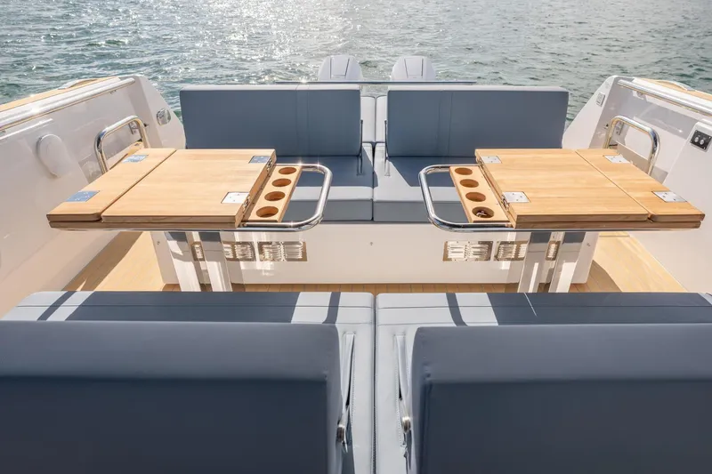 Slide: The Image of Luxury seating area on 2026 Fjord 39 XP yacht with wooden tables and ocean view. - 8