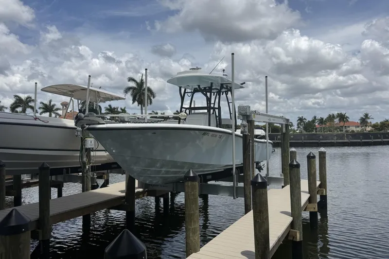 Slide: The Image of 2023 Yellowfin 26 Hybrid boat docked at marina under cloudy sky. - 1