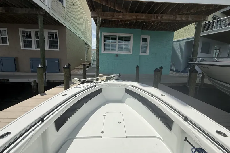 Slide: The Image of 2023 Yellowfin 26 Hybrid boat docked between waterfront houses. - 10