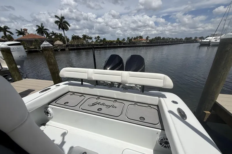 Slide: The Image of 2023 Yellowfin 26 Hybrid boat docked by a scenic waterfront with palm trees. - 27