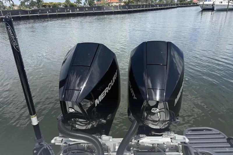 Slide: The Image of Twin Mercury outboard engines on a 2023 Yellowfin 26 Hybrid boat, docked by the water. - 28