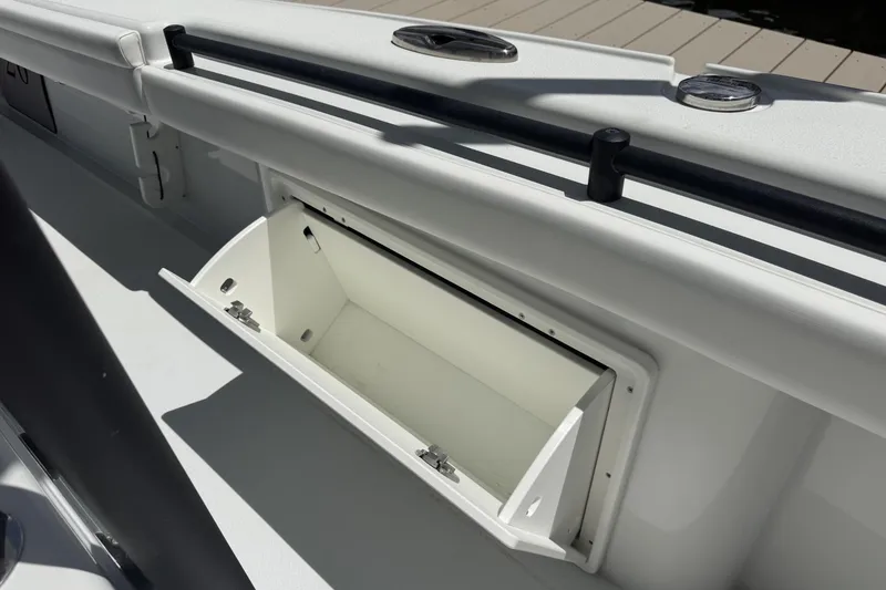 Slide: The Image of 2023 Yellowfin 26 Hybrid boat storage compartment, open and empty, with sleek white finish. - 30