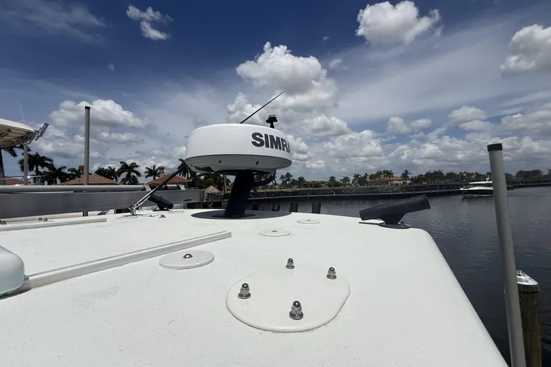 Slide: The Image of 2023 Yellowfin 26 Hybrid boat with Simrad radar, docked under a partly cloudy sky. - 35